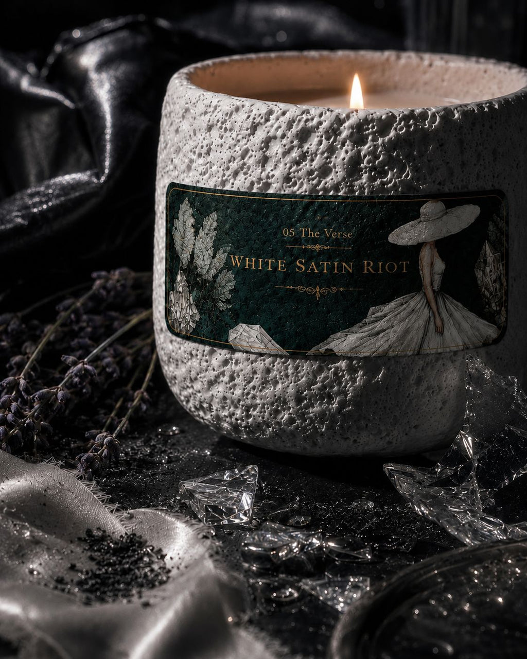 Close-up of the White Satin Riot stone candle with its gowned-figure label and lavender